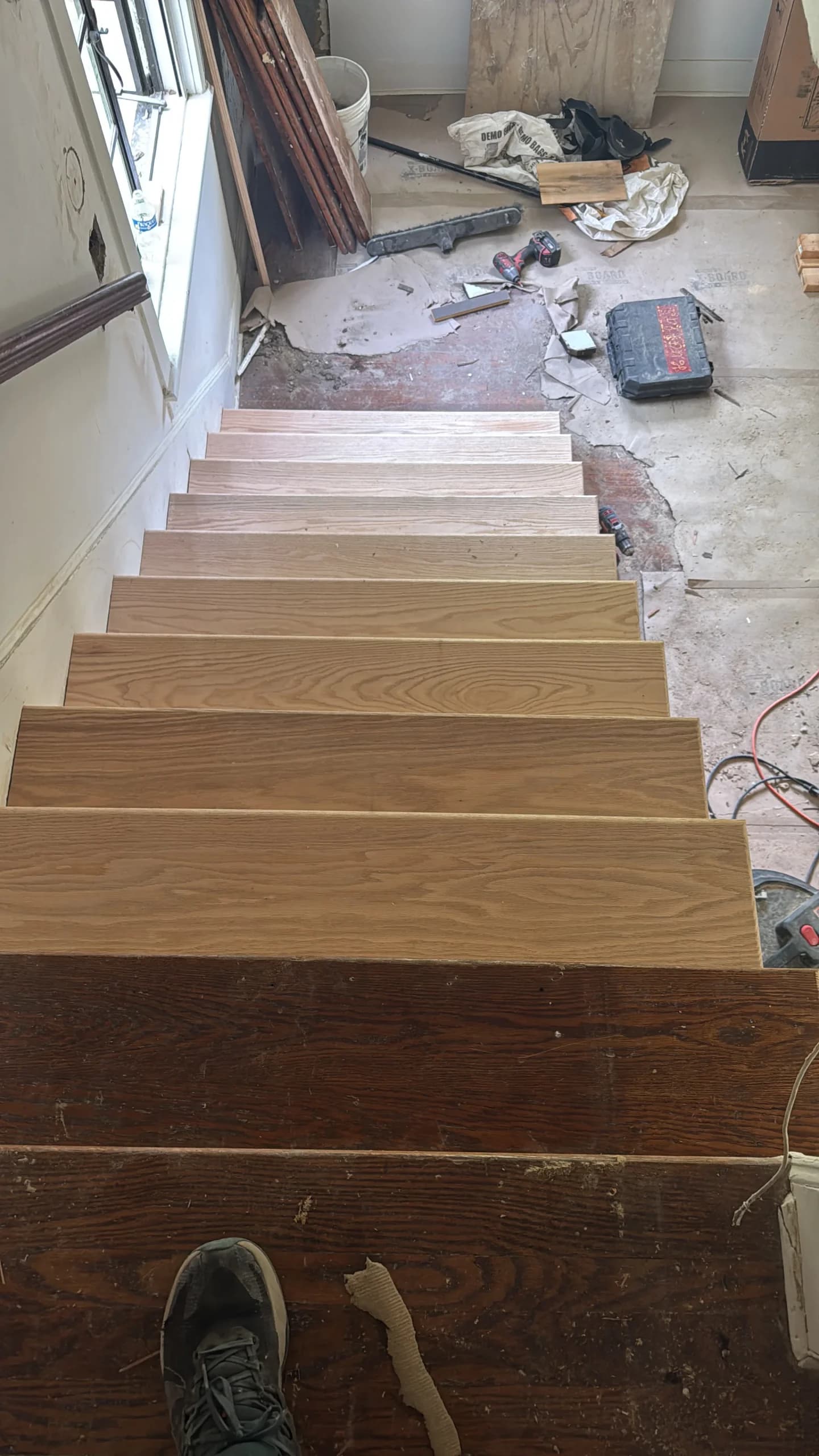 New wood stair treads being fitted on a staircase during renovation - Greater Homes Solutions LLC