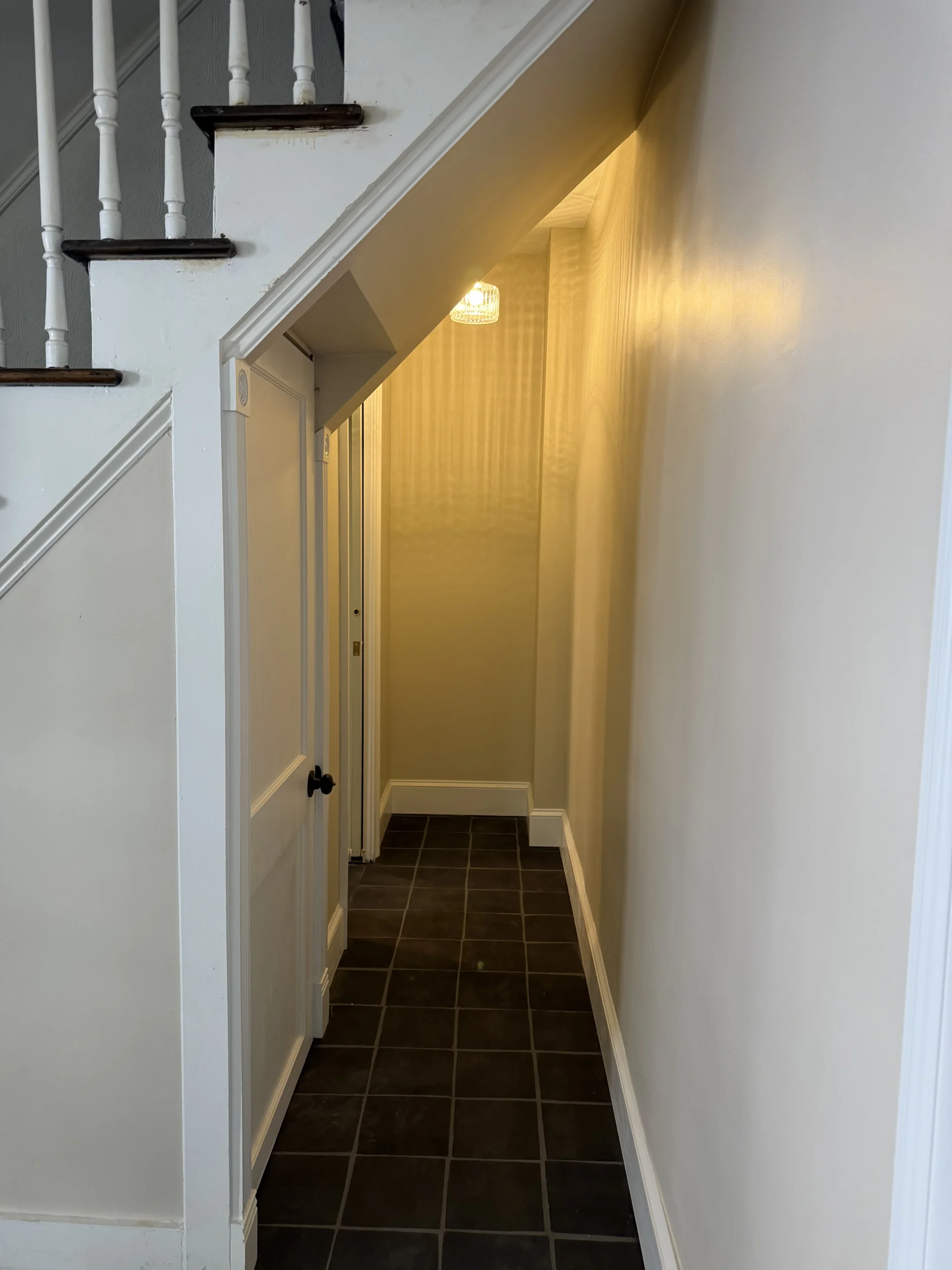 Entry hall with a staircase, dark tile floor and freshly painted walls - interior renovation by Greater Homes Solutions LLC