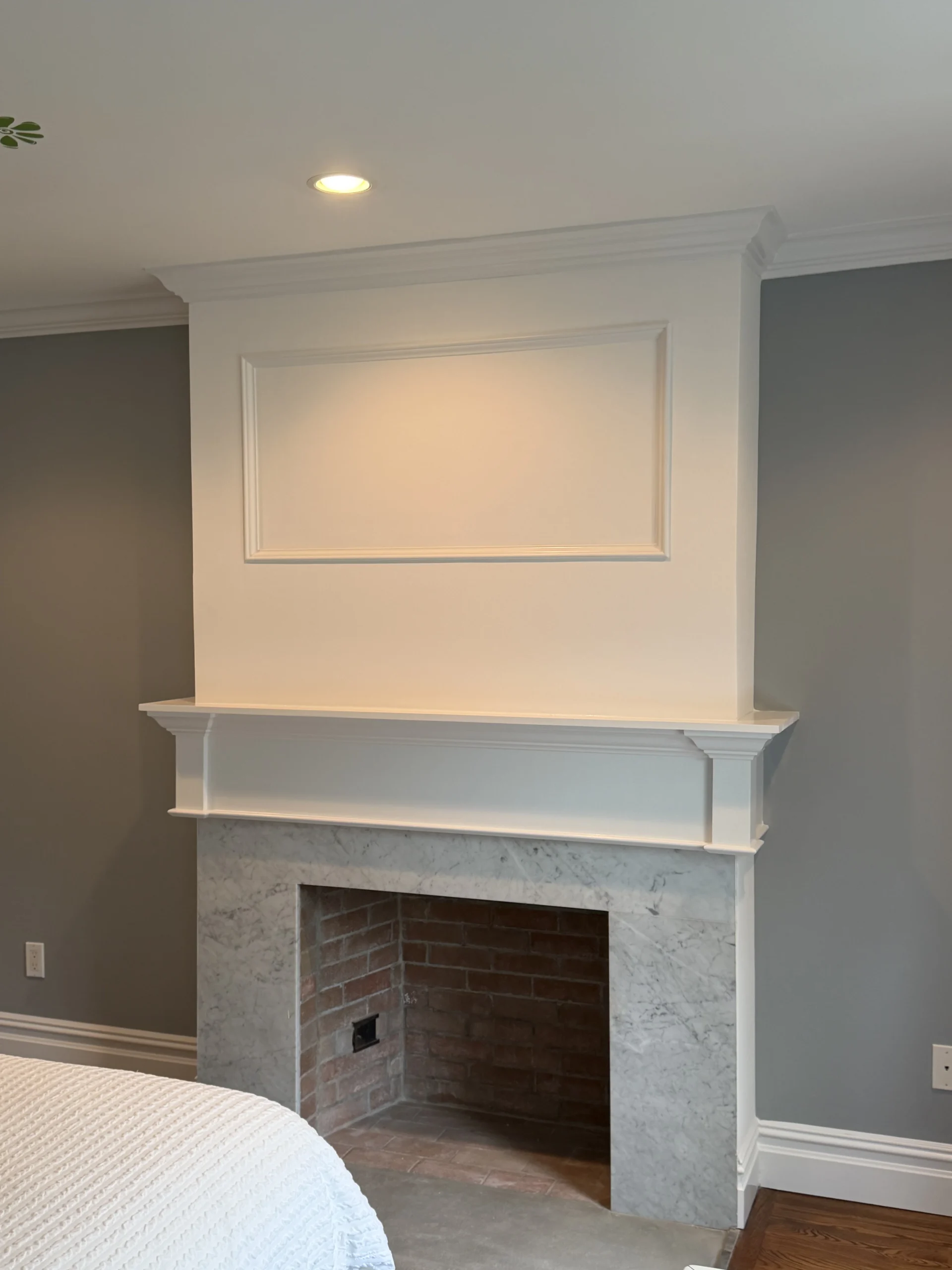 Bedroom fireplace with a new white mantel and marble surround on a grey wall - Greater Homes Solutions LLC