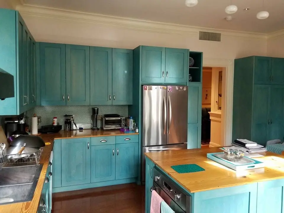 Kitchen with turquoise painted cabinets, a butcher block island and a stainless steel refrigerator - kitchen remodeling by Greater Homes Solutions LLC