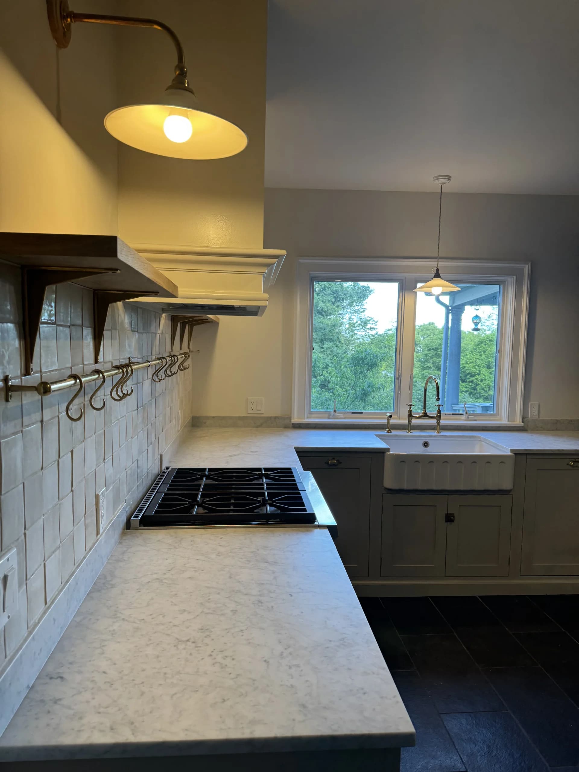 Kitchen with a farmhouse sink, gas cooktop, tile backsplash and a pendant light over the counter - kitchen remodeling by Greater Homes Solutions LLC