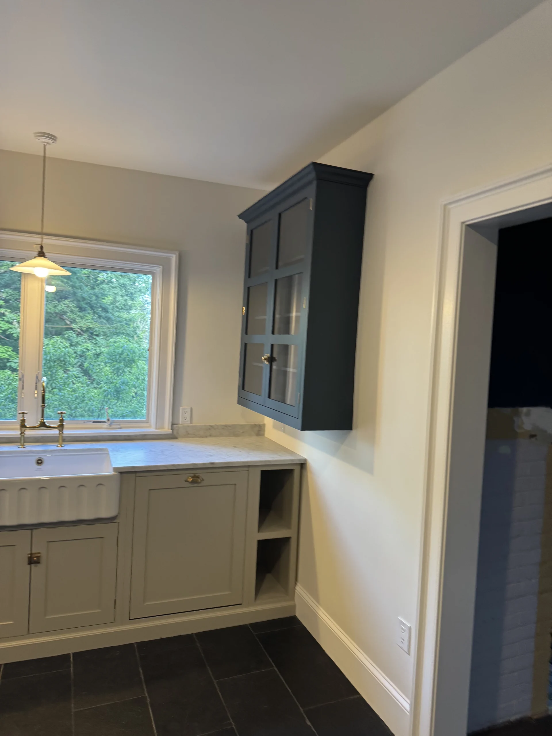 Kitchen corner with a farmhouse sink, a dark blue upper cabinet and a slate tile floor - kitchen remodeling by Greater Homes Solutions LLC