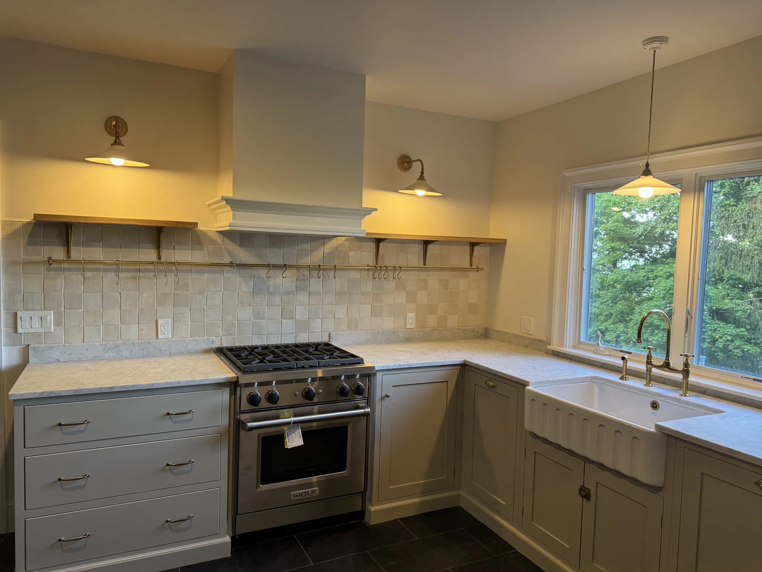 Kitchen with a stainless range, marble tile backsplash, open shelves and a farmhouse sink - kitchen remodeling by Greater Homes Solutions LLC