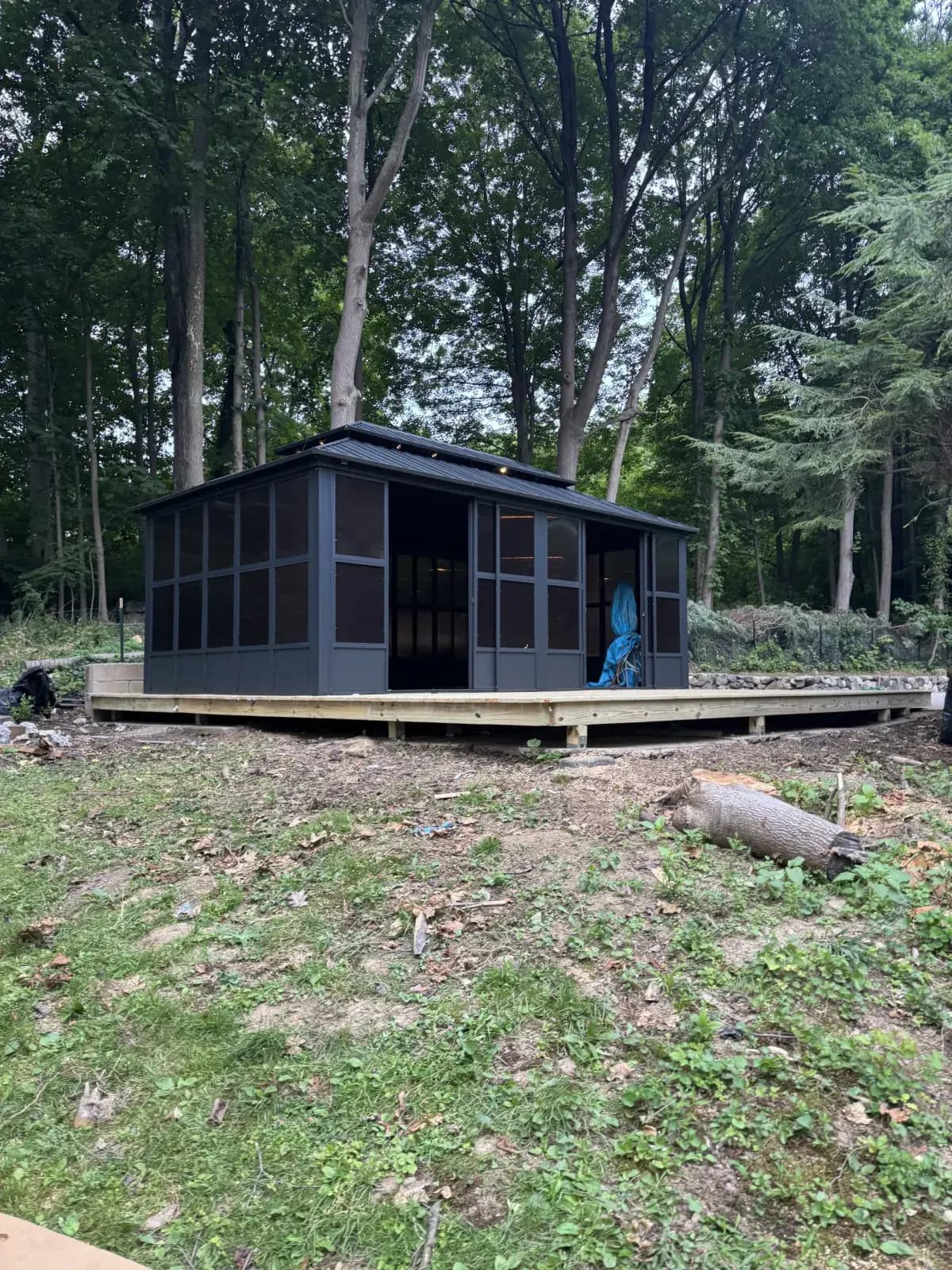 Finished screened gazebo with a black roof on a wood deck in the woods - built by Greater Homes Solutions LLC