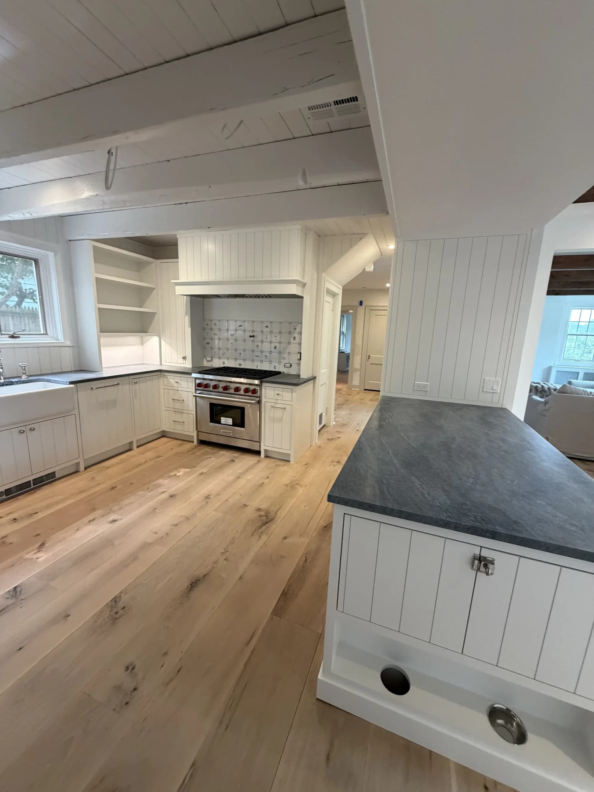 Kitchen with a shiplap island, a stainless range and wide plank oak flooring - kitchen remodeling by Greater Homes Solutions LLC