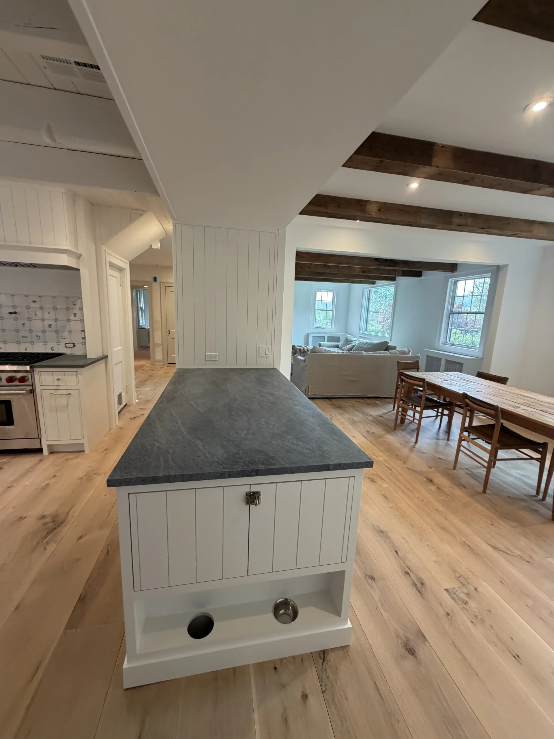Kitchen island with a slate countertop looking toward a dining area with a wood table - kitchen remodeling by Greater Homes Solutions LLC